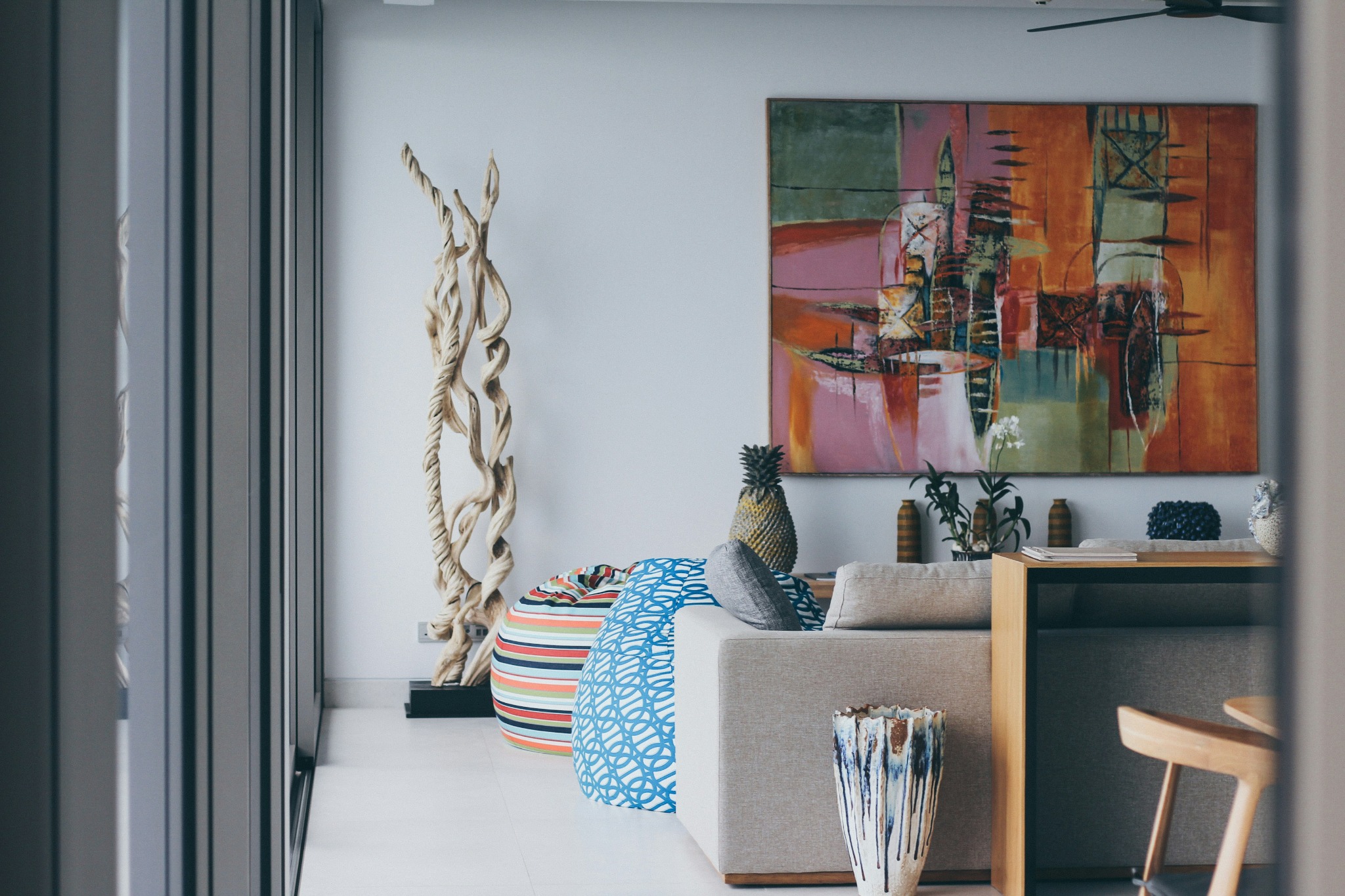 A light-filled living room with art, warm wood and layered furnishings